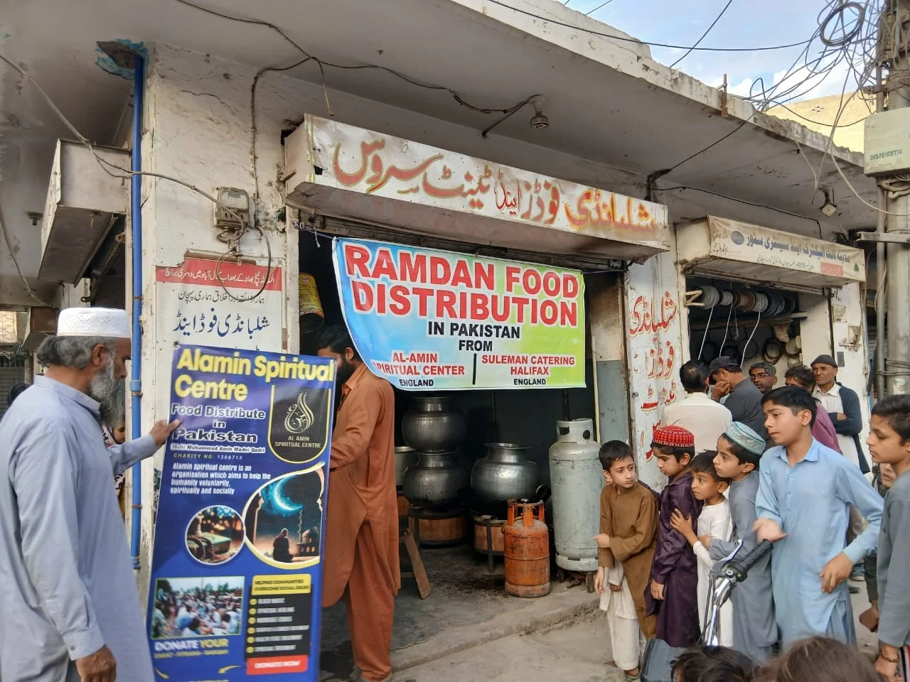 Alamin’s Ramadan food distribution banner and cooking pots